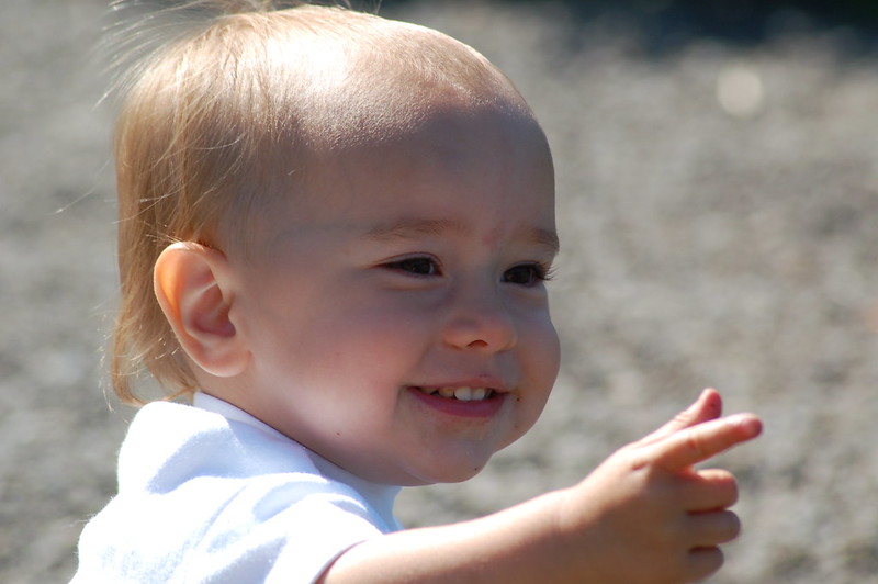 A closeup of a baby pointing to the right.