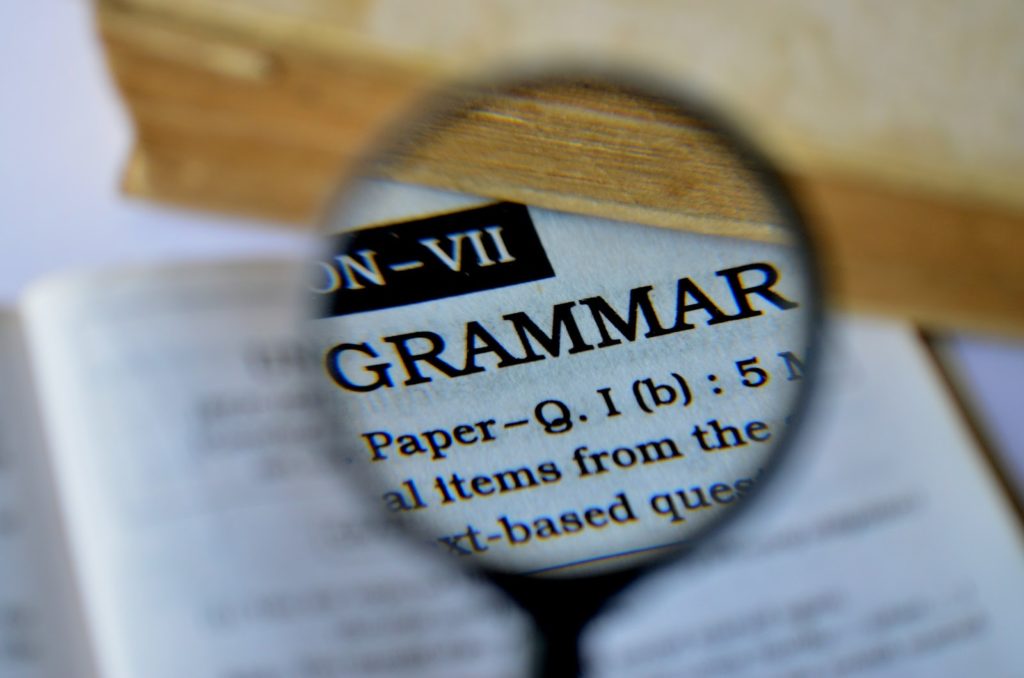 Grammar, magnifier, words on a page