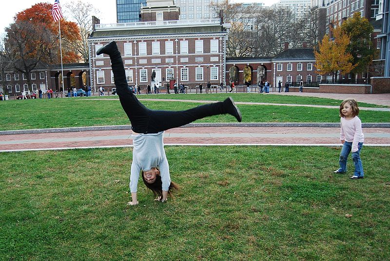 Image of a girl performing a cartwheel in front of Independence Hall in Philadelphia
