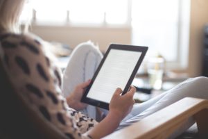  photo of a person reading on a kindle